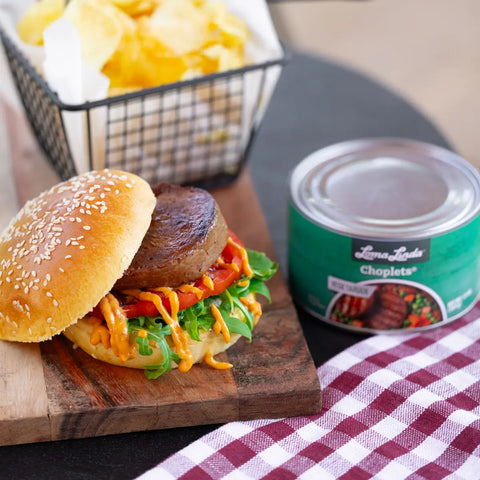 Choplets served on a sesame bun with lettuce, tomato, and orange fry sauce – plant-based pork alternative in a classic sandwich style