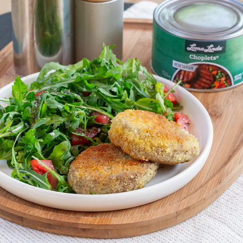Breaded and fried Choplets plated with a fresh arugula salad – crispy plant-based pork alternative paired with greens