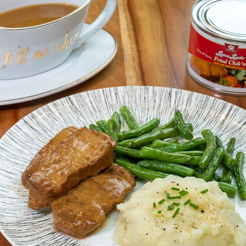 Loma Linda Fried Chik'n with Gravy served with mashed potatoes, green beans, and gravy on a plate, plant-based chicken alternative.