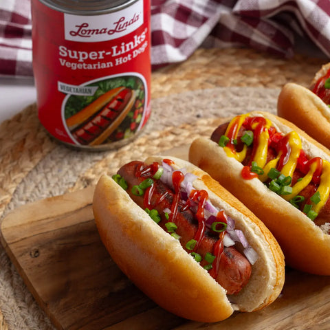 Super Links served in three buns with ketchup, diced onions, and green onions – plant-based hot dog alternative plated for a classic meal