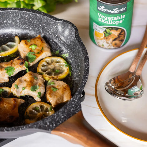 Vegetable Skallops sautéed in a cast iron pan with lemon slices and parsley – vegan scallop alternative prepared with fresh herbs and citrus