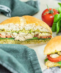 Loma Linda Chik’n Broth served on a chicken salad sandwich with pesto, lettuce, and tomato on a bun, a plant-based vegan protein in a mild vegetable broth.