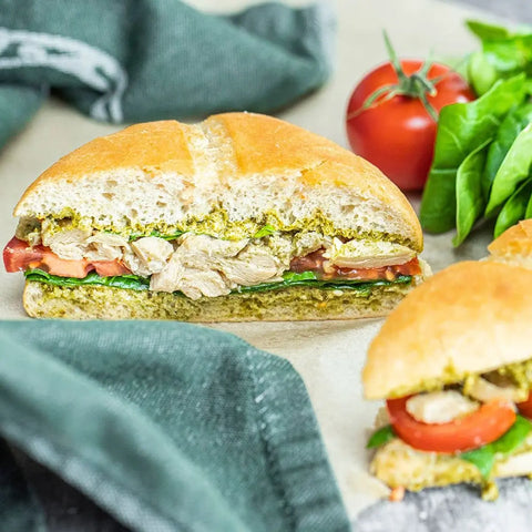 Loma Linda Chik’n Broth served on a chicken salad sandwich with pesto, lettuce, and tomato on a bun, a plant-based vegan protein in a mild vegetable broth.