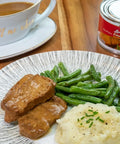 Loma Linda Fried Chik'n with Gravy served with mashed potatoes, green beans, and gravy on a plate, plant-based chicken alternative.