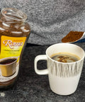 A person spooning Kaffree Roma into a mug, highlighting the ease of preparation for this caffeine-free coffee alternative.