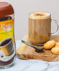 Kaffree Roma in a coffee cup with a plate of cookies, illustrating a comforting caffeine-free drink.