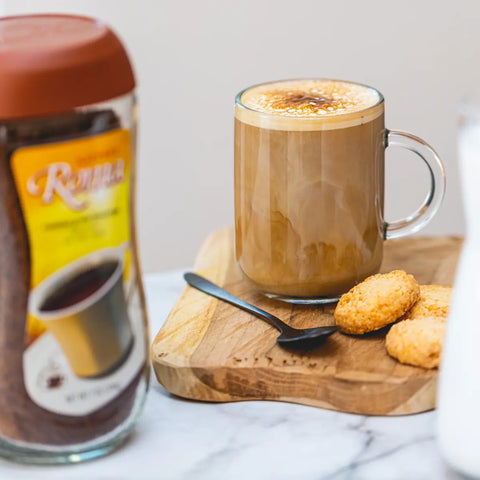 Kaffree Roma in a coffee cup with a plate of cookies, illustrating a comforting caffeine-free drink.