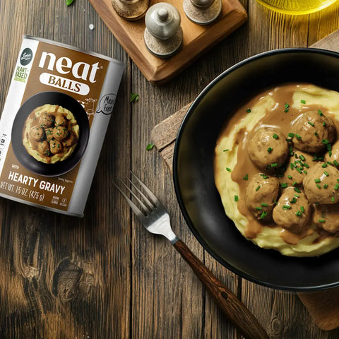 Plant-Based Meatballs with rich gravy over mashed potatoes, finished with fresh green onions - Loma Linda Neat Balls