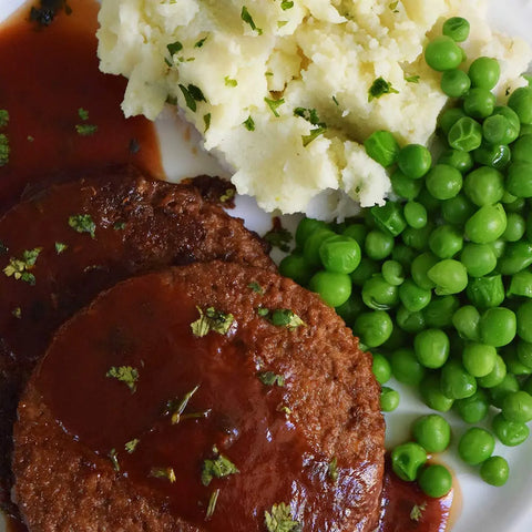 Swiss Stake with Gravy served on a plate with vegetables, vegetarian meal