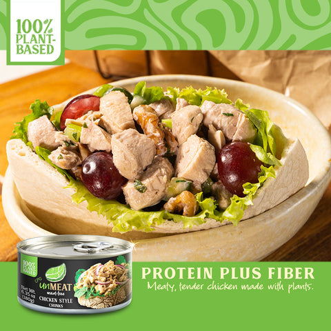 Plant-based chicken salad in a tortilla with a can of UniMeat chicken style chunks on a wooden table.
