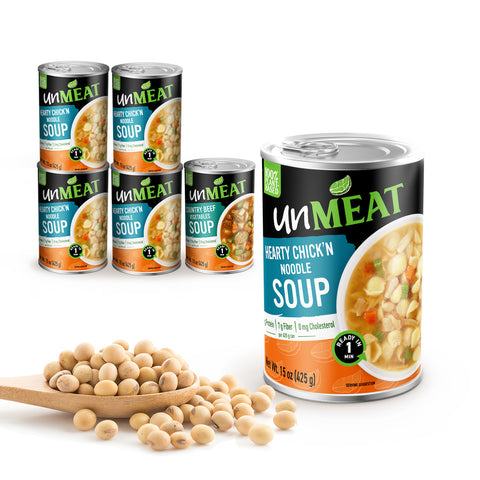 Six cans of UnMeat chicken noodle soup with a scoop of soybeans on a white background