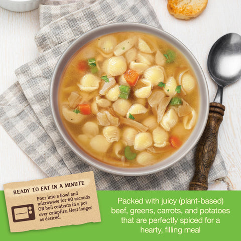 Bowl of hearty chicken noodle soup with text about plant-based ingredients on a checkered cloth.