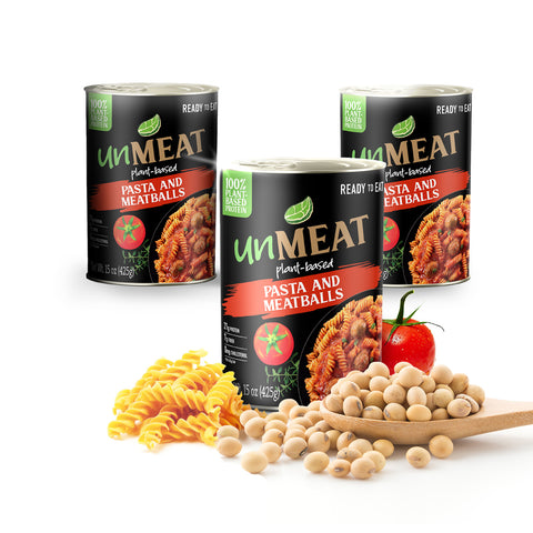 Three cans of 'UnMeat' pasta and meatballs with ingredients like pasta, beans, and a tomato on a white background.