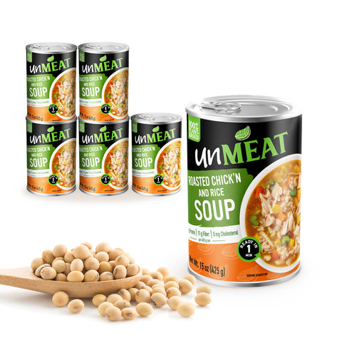 6 Cans of UnMEAT roasted chicken and rice soup with a wooden spoonful of beans on a white background
