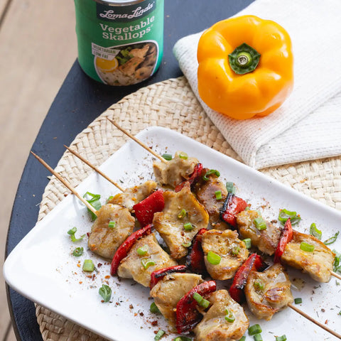 Vegetable Skallops on wooden skewers with grilled red peppers – vegan scallop alternative garnished with soy sauce and green onions